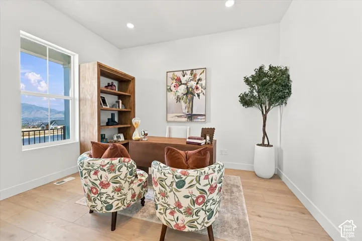Neutral-toned room featuring wide-plank wood-finish flooring, recessed lighting, and a window with mountain scenery