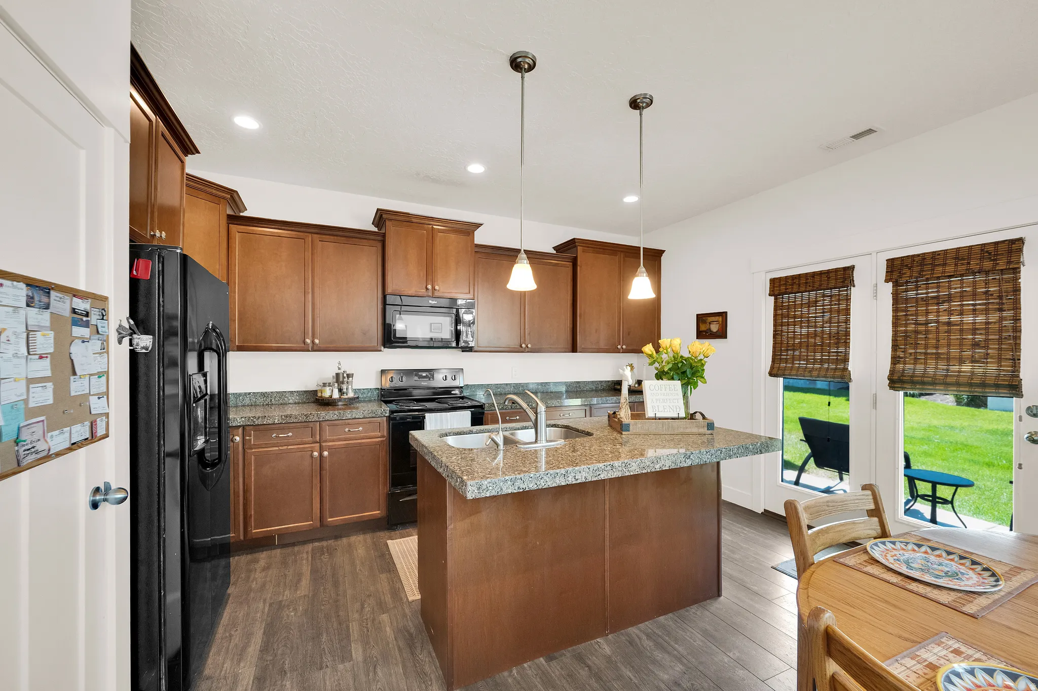 Contemporary kitchen featuring wood-finish cabinetry, granite countertops, and stainless steel appliances
