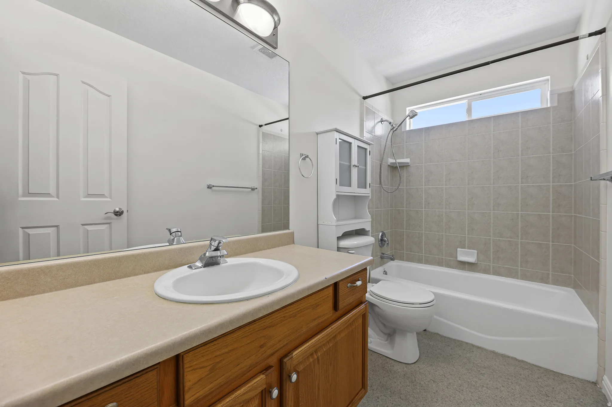 Bathroom vanity with a built-in sink, ample counter space, and wood cabinetry