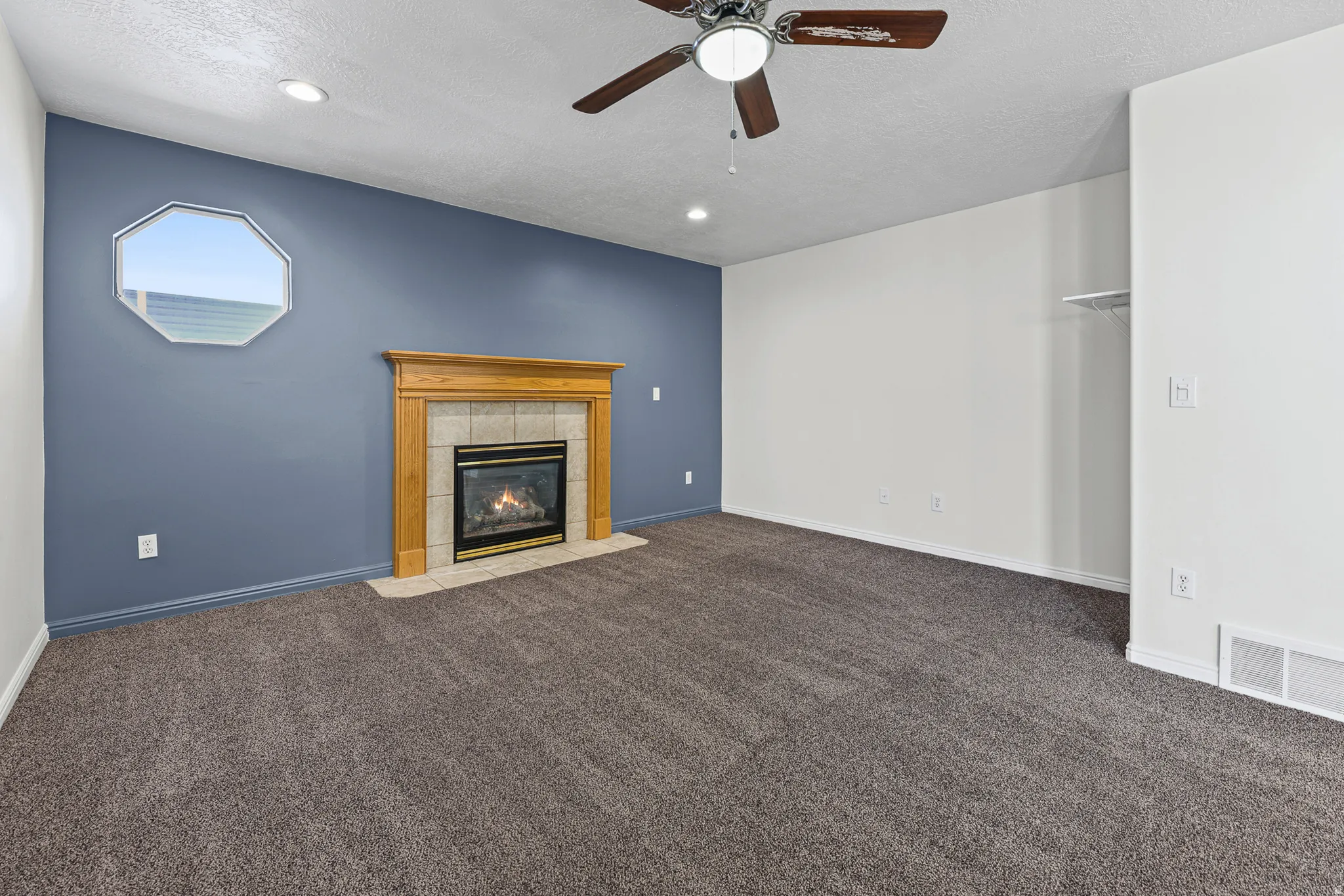 Living area featuring a fireplace with a light-toned tile surround and wood mantel