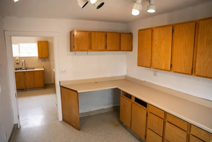 L-shaped countertop with integrated desk space, complemented by extensive wood-finish cabinetry