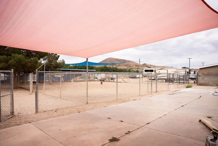 Expansive outdoor concrete pad with a large pink shade sail overhead