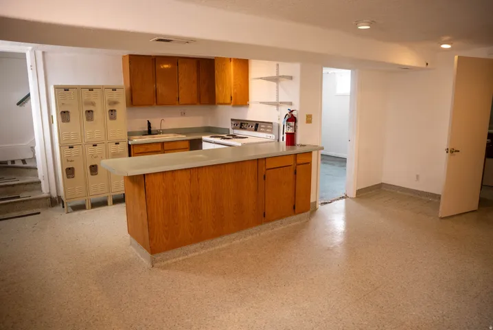 Kitchen area featuring wood cabinetry, light-colored countertops, and white appliances