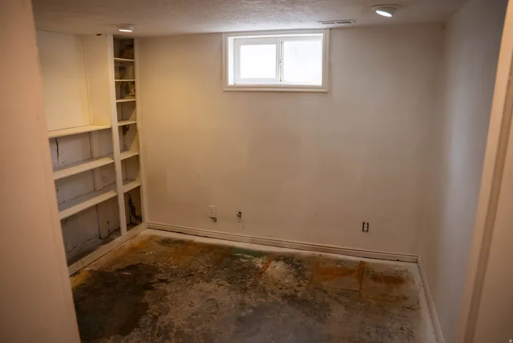 Room featuring a built-in shelving unit, white walls, and a single window