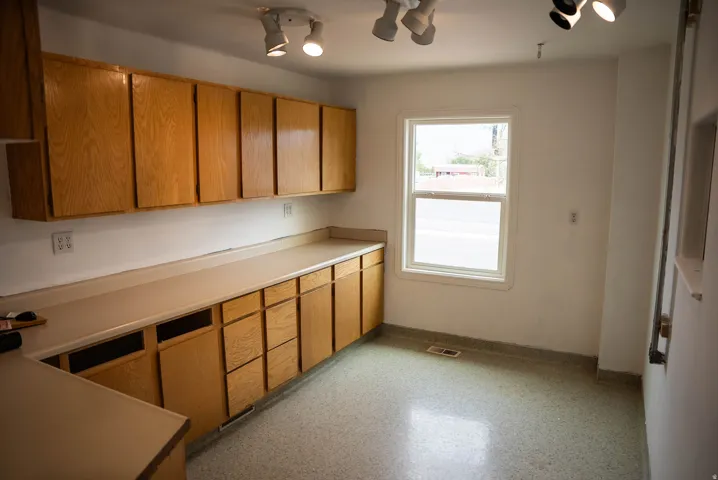 Expansive wood-finish cabinetry and countertops, featuring a full wall of upper and lower storage