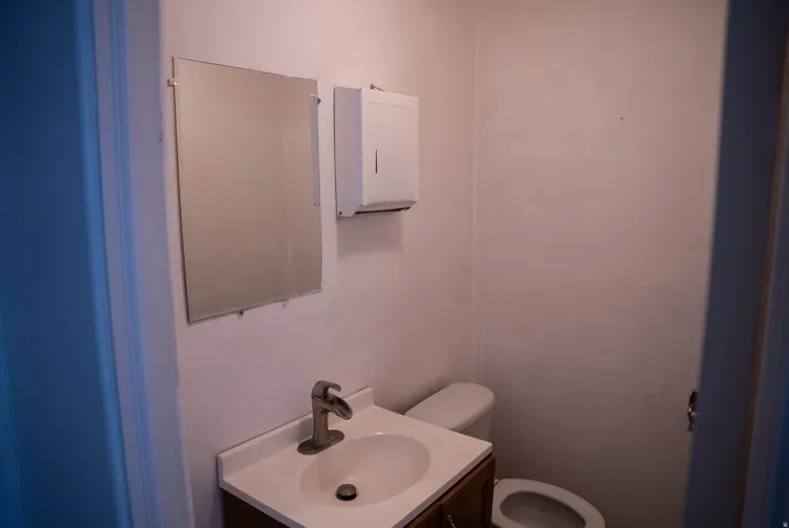 Bathroom featuring a single vanity with an undermount sink, brushed nickel faucet, and a wall-mounted mirror