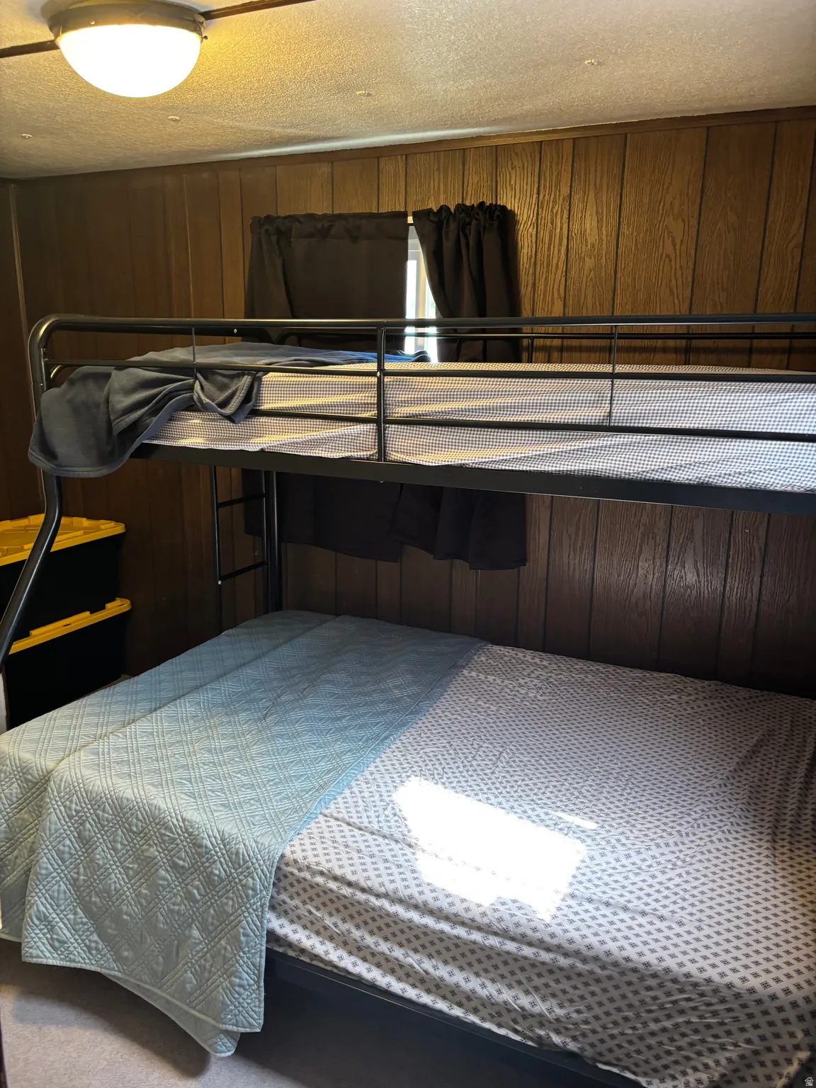 Bedroom featuring wood-panel walls and a built-in bunk bed frame
