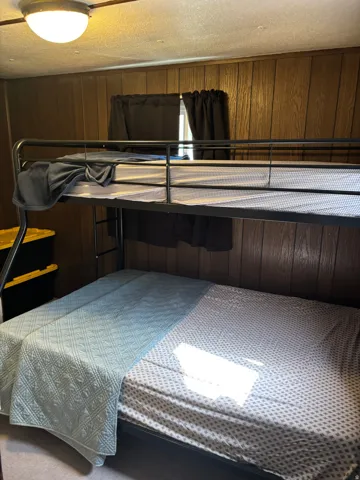 Bedroom featuring wood-panel walls and a built-in bunk bed frame