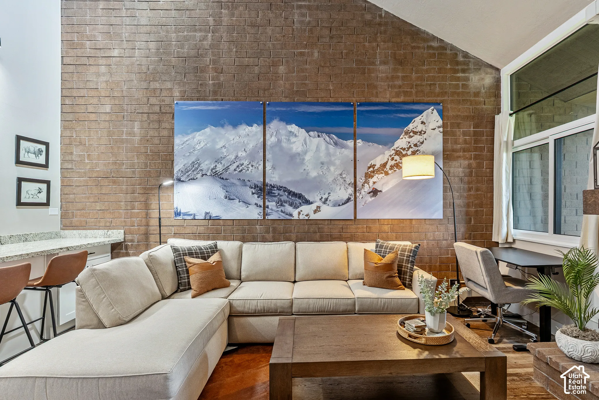 Exposed brick wall accenting a spacious living area with vaulted ceilings