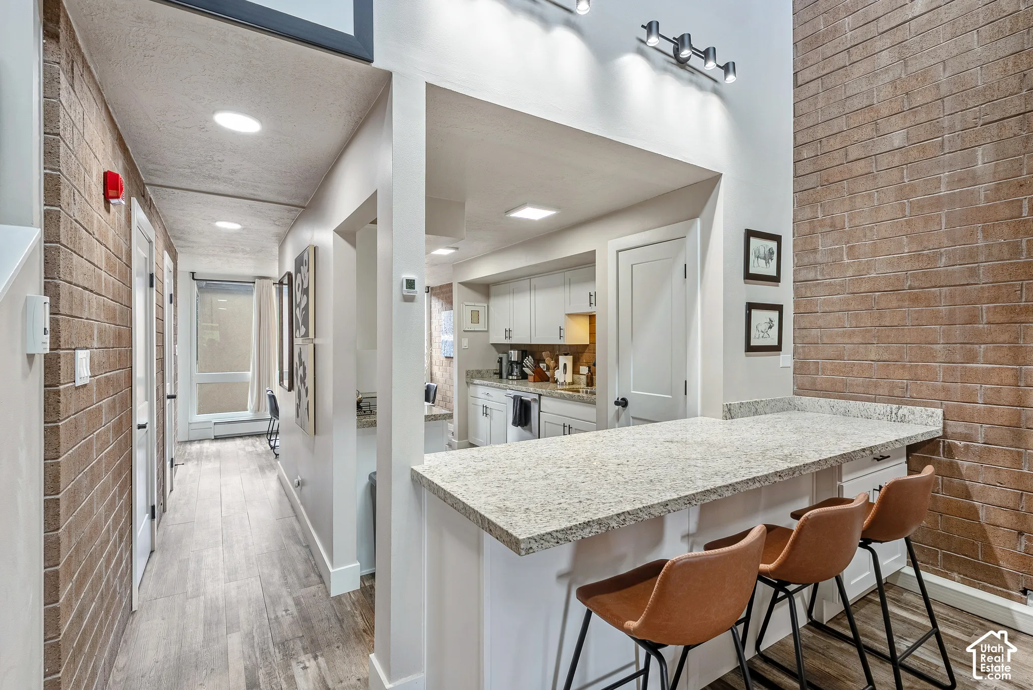 Kitchen featuring light cabinetry, a peninsula with a stone countertop, and recessed lighting