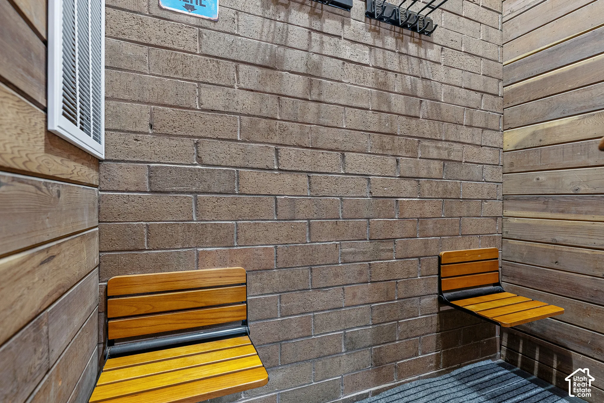 Textured brick wall with two integrated wood-slat folding benches