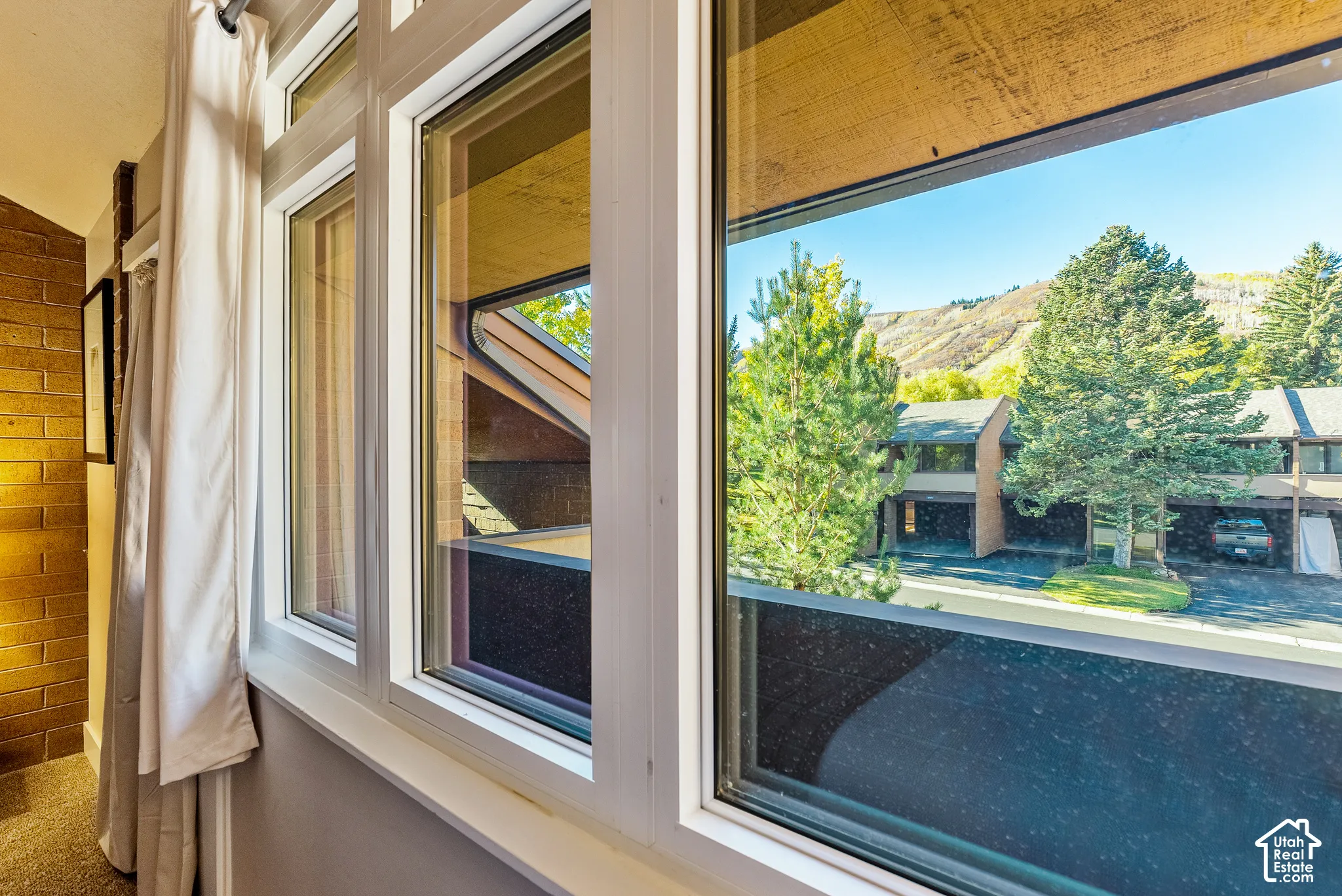 Multiple windows with white frames offer expansive mountain scenery