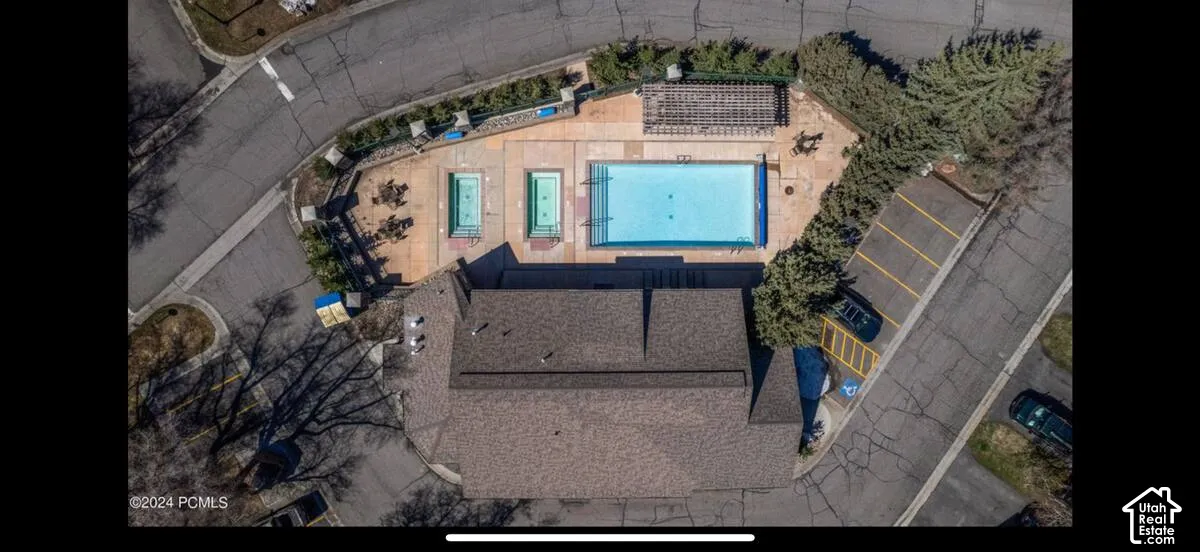 Community recreation area featuring a large swimming pool, two smaller pools, and a pergola-covered patio
