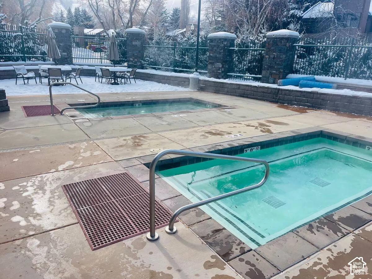 Outdoor aquatic area featuring two separate in-ground spas with handrails and integrated steps