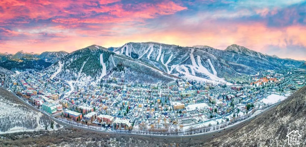 Snow-covered mountain town with extensive residential areas and commercial buildings nestled in a valley