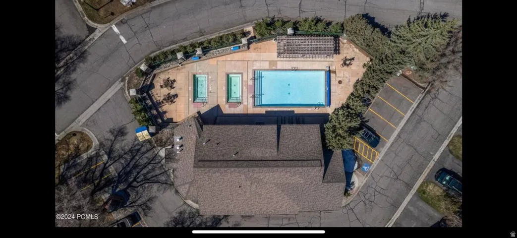 Community recreation area featuring a large swimming pool, two smaller pools, and a pergola-covered patio