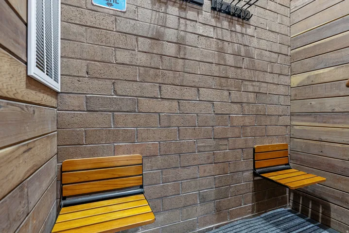 Textured brick wall with two integrated wood-slat folding benches