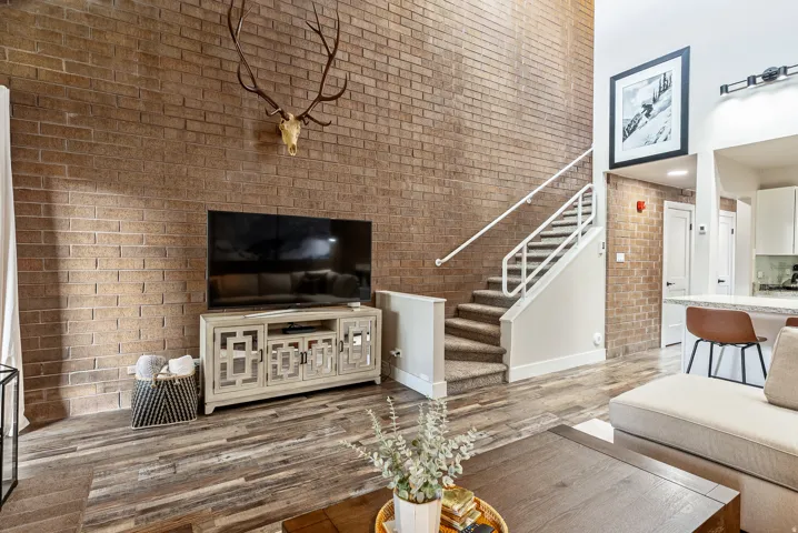 Two-story brick accent wall with wood-finish flooring