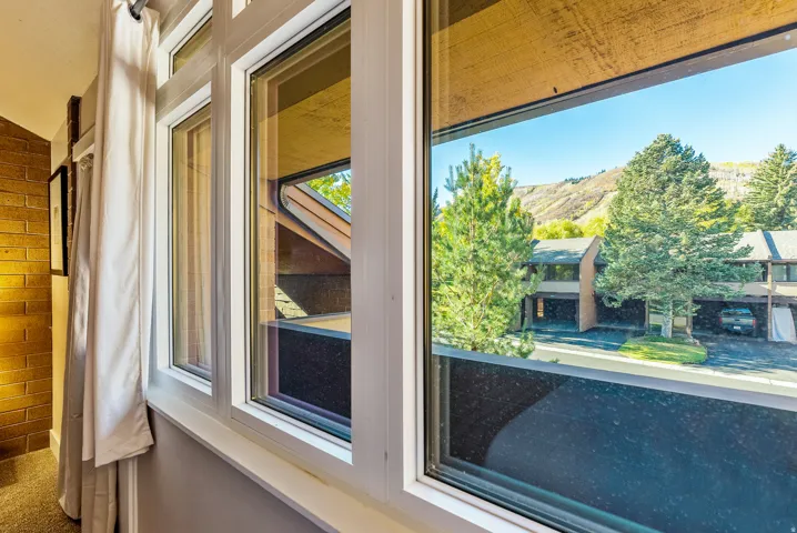 Multiple windows with white frames offer expansive mountain scenery