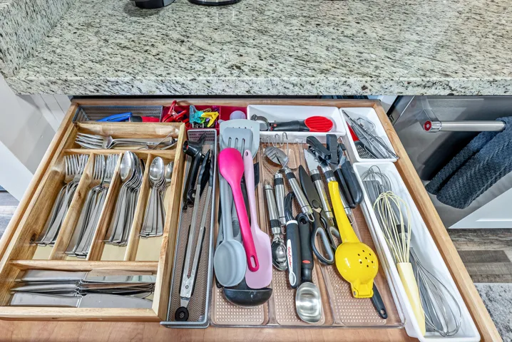 Kitchen drawer with integrated wooden cutlery organizer and assorted utensil storage