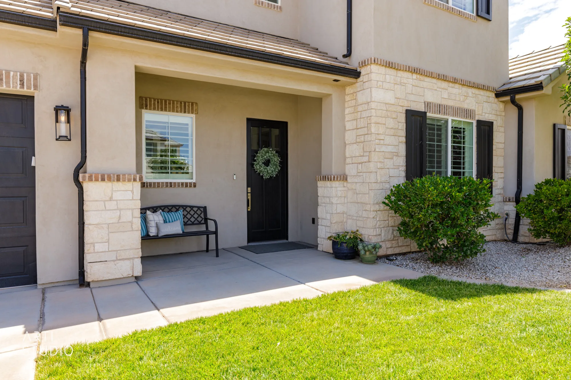 Exterior featuring a covered entryway, stucco facade, and stone veneer accents