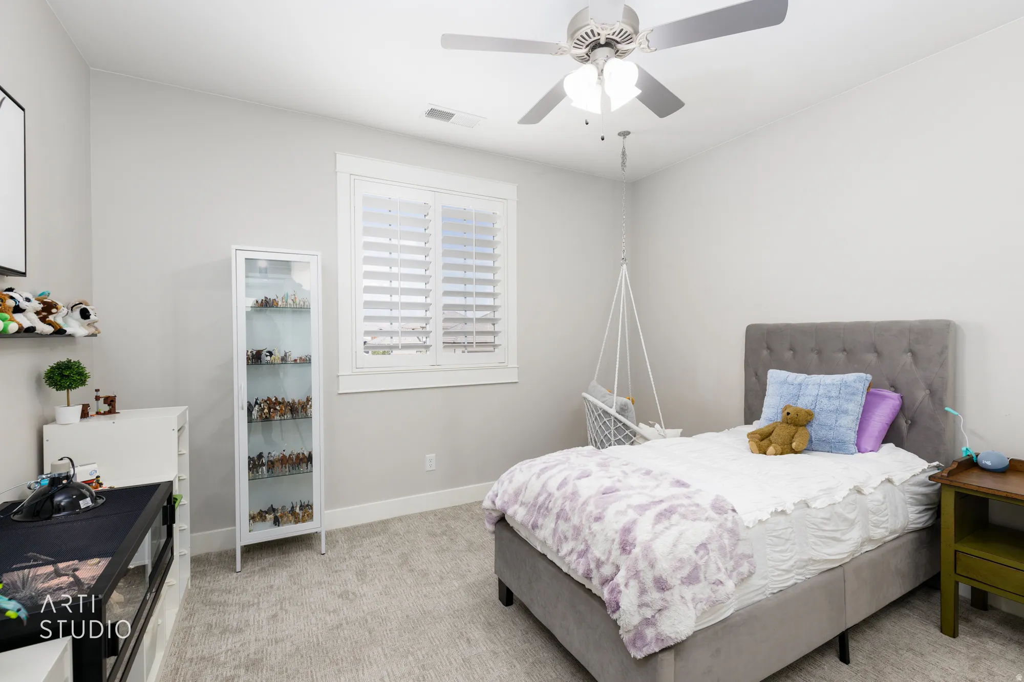 Interior space featuring light gray walls, a window with white louvered shutters, and light-colored patterned carpeting