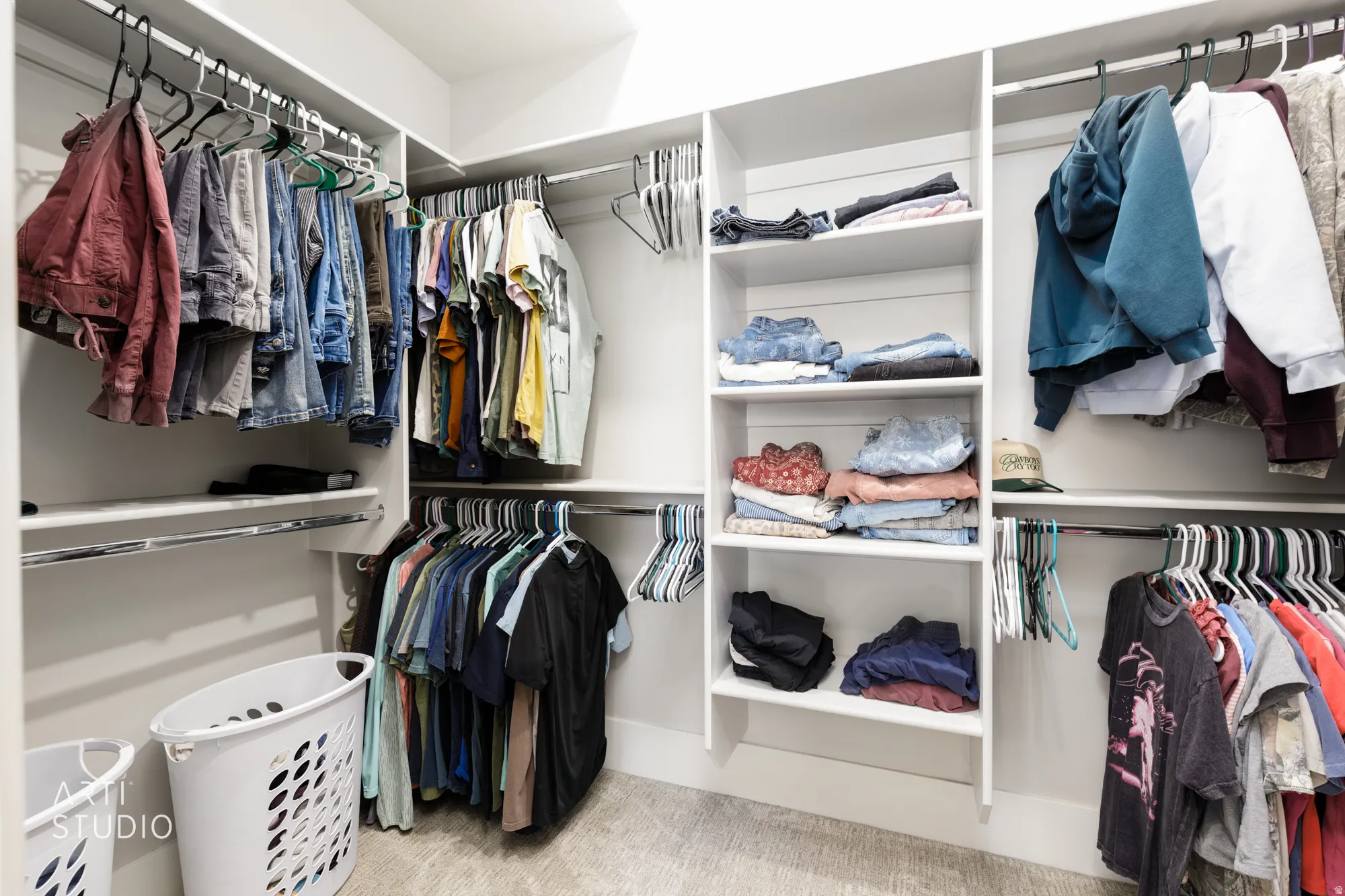 Custom closet system featuring white shelving and chrome hanging rods