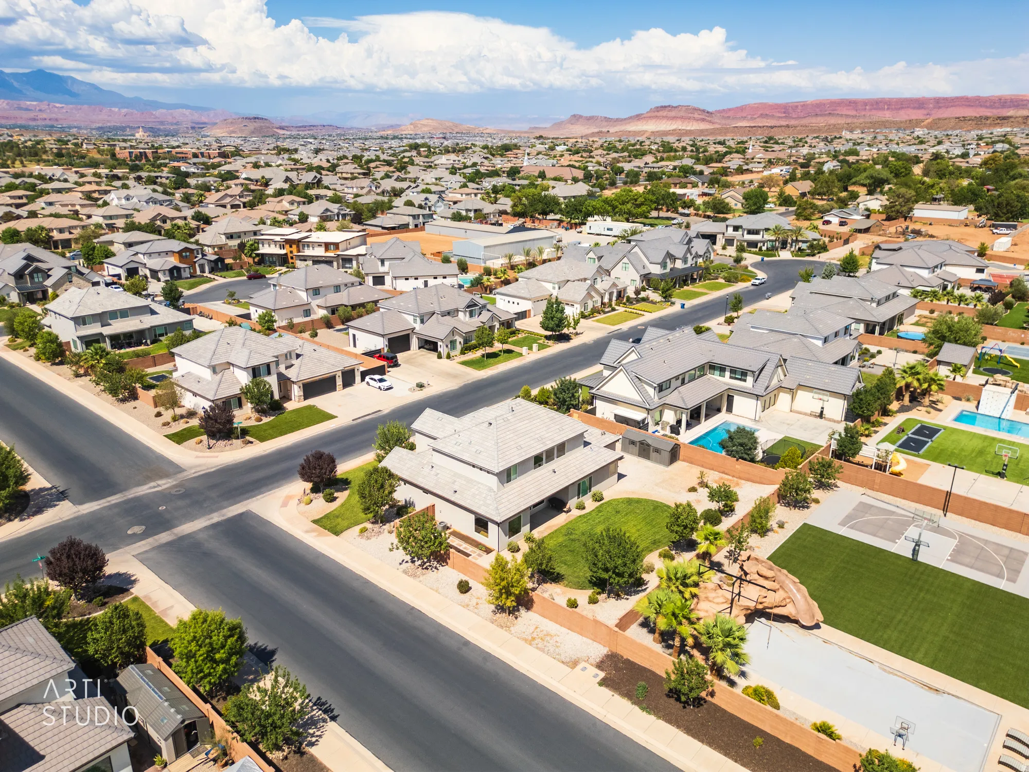 Expansive neighborhood setting featuring a variety of architectural styles, mature landscaping, and red rock mountain backdrop