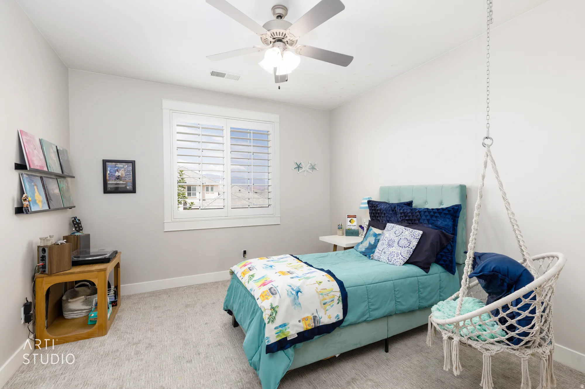 Bedroom featuring light gray walls, plush gray carpeting, and a white ceiling fan with integrated lighting