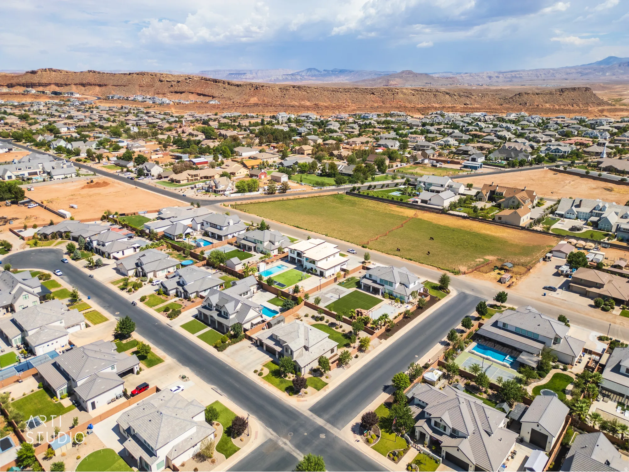 Expansive aerial view of a residential neighborhood with diverse architectural styles, featuring numerous properties with private swimming pools and landscaped yards