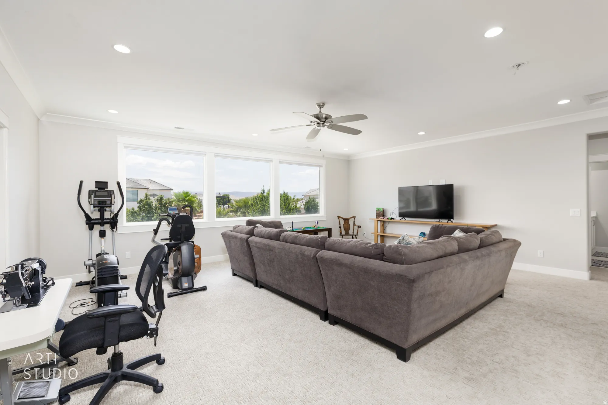 Spacious room with light neutral wall paint, recessed lighting, and a ceiling fan