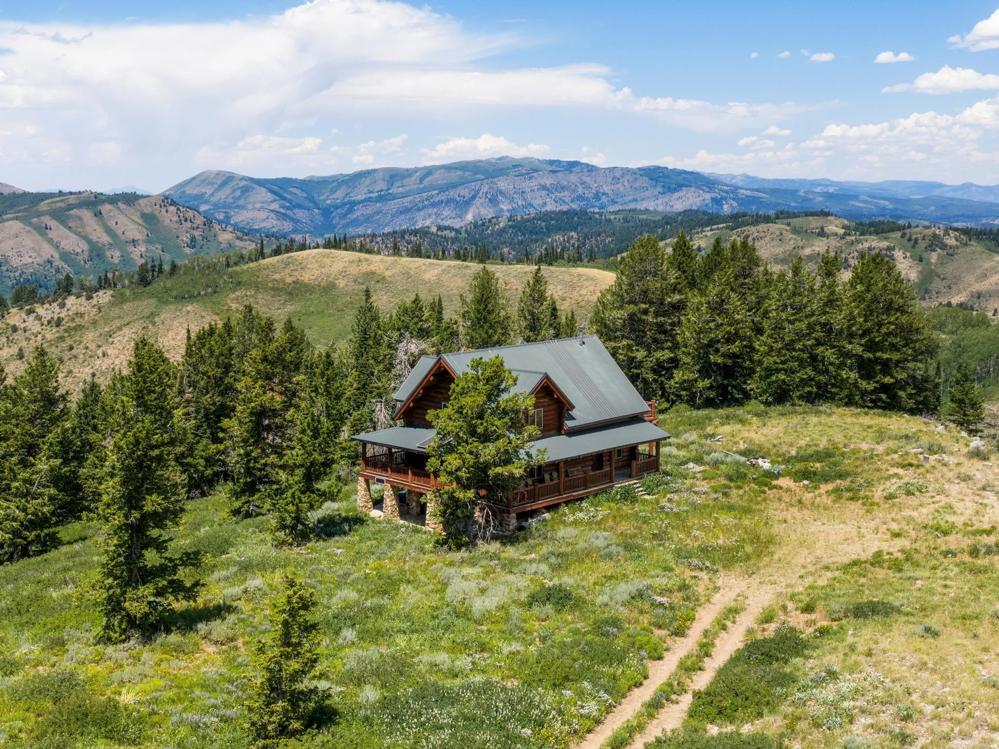 Log cabin residence set amidst a mountainous landscape with mature evergreen trees