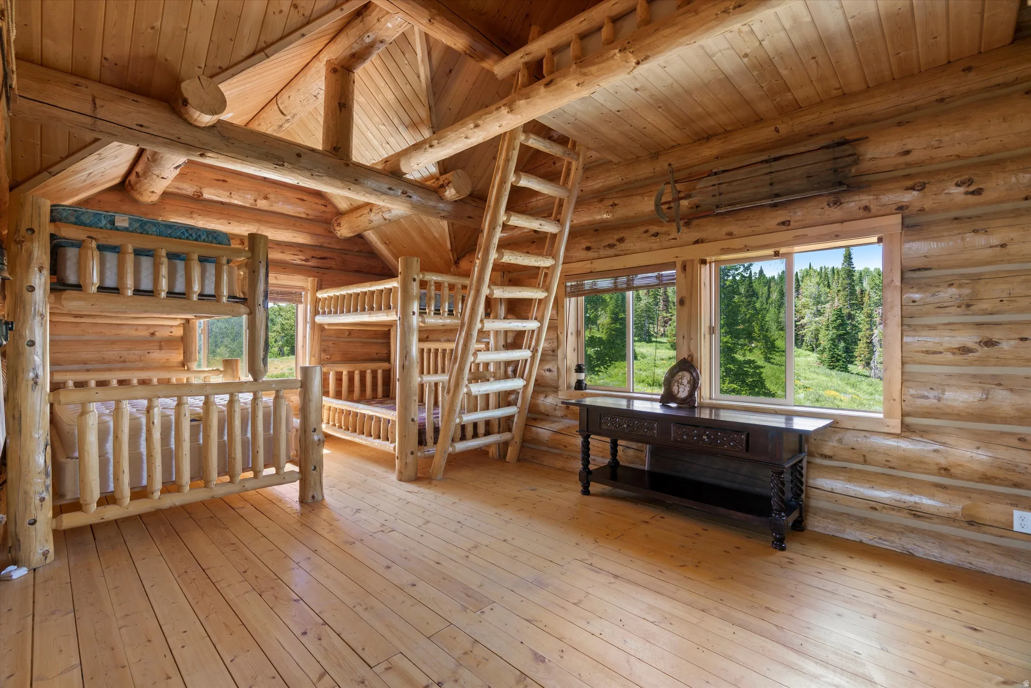 Log cabin interior featuring exposed log walls, ceilings, and structural beams