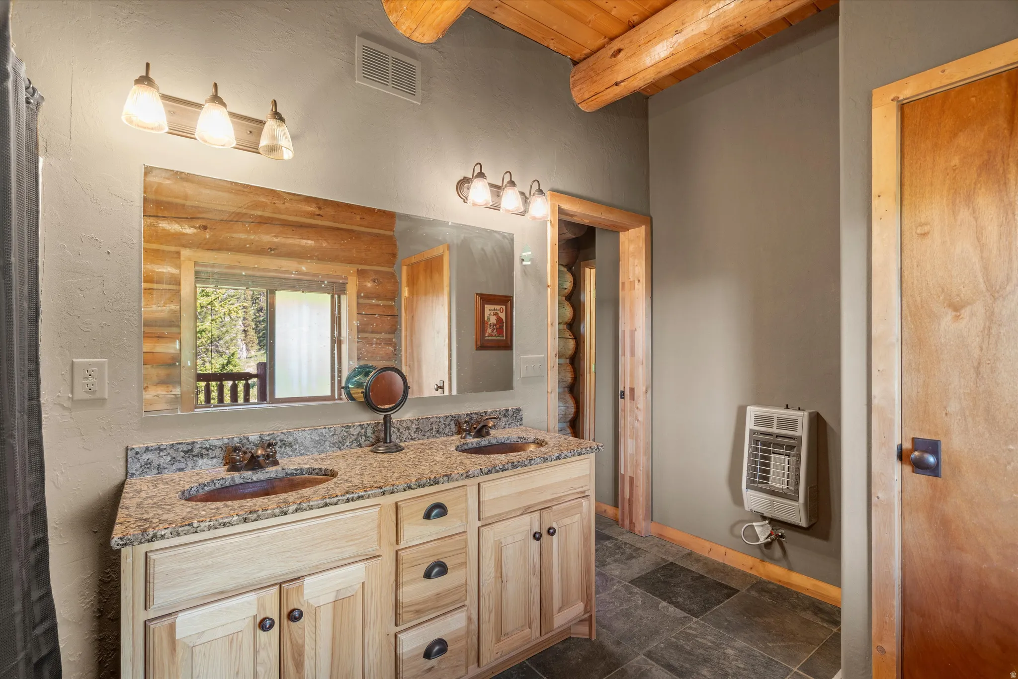 Bathroom featuring a double vanity with granite countertop, integrated sinks, and wood-finish cabinetry