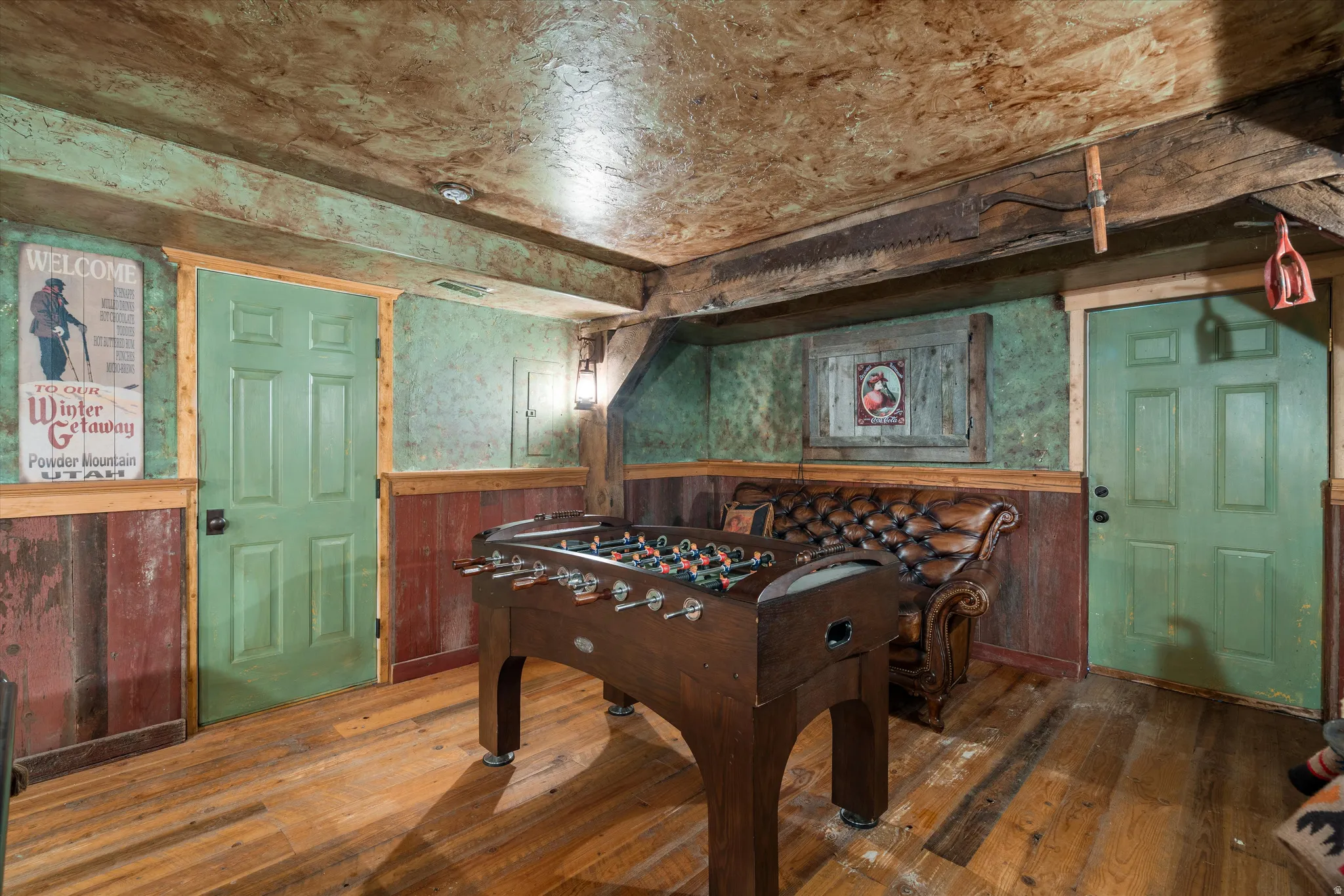 Wood-finish flooring with wood paneling and green textured walls