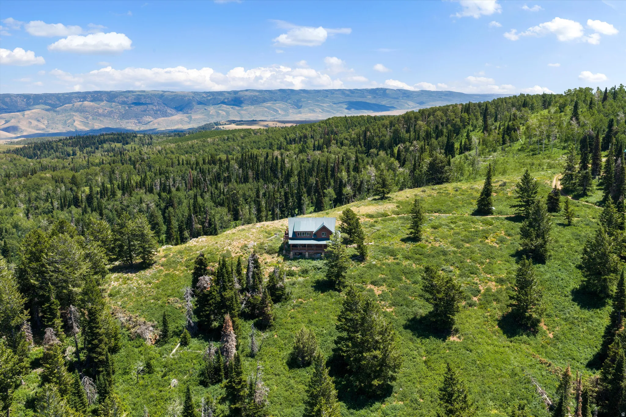 Mountain-surrounded property with a cabin-style residence set amidst lush green hills