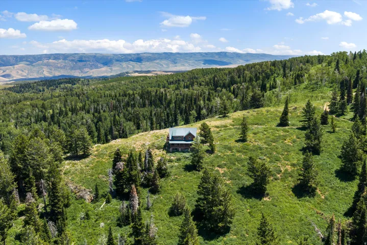 Mountain-surrounded property with a cabin-style residence set amidst lush green hills