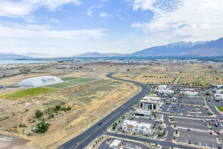 Aerial perspective showcasing a sprawling landscape with distant mountains and a body of water