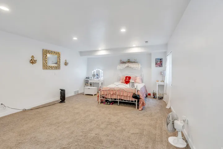 Spacious room featuring neutral carpet flooring, recessed lighting, and white painted walls