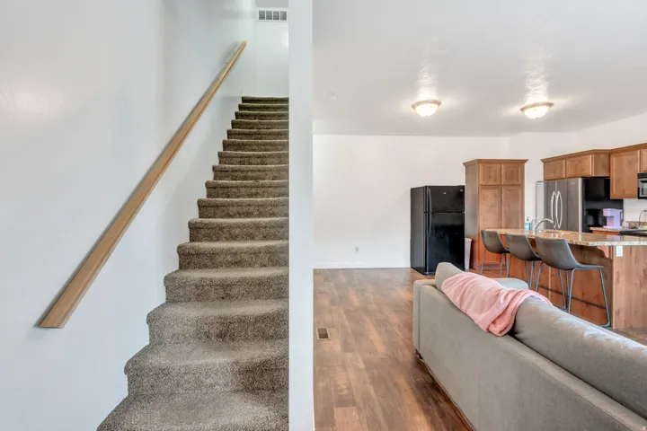 Open-concept living space featuring wood-finish flooring and a kitchen island with seating