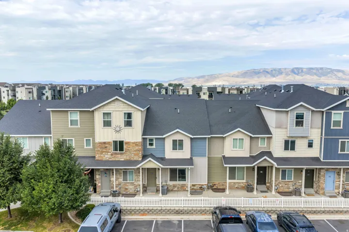 Modern townhome community featuring varied siding textures, stone facade elements, dark shingle roofing, and individual covered entryways