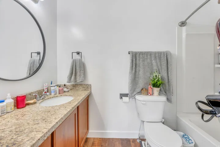 Bathroom vanity featuring a light-colored stone-finish countertop with an undermount sink