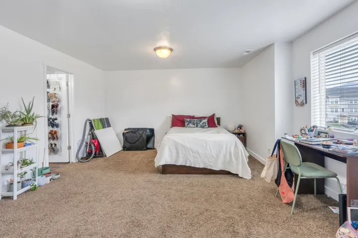 Spacious room featuring carpeting and a large window with blinds