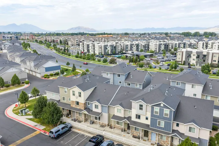 Contemporary townhomes with multi-textured facades, individual front porches, and dark shingle roofs