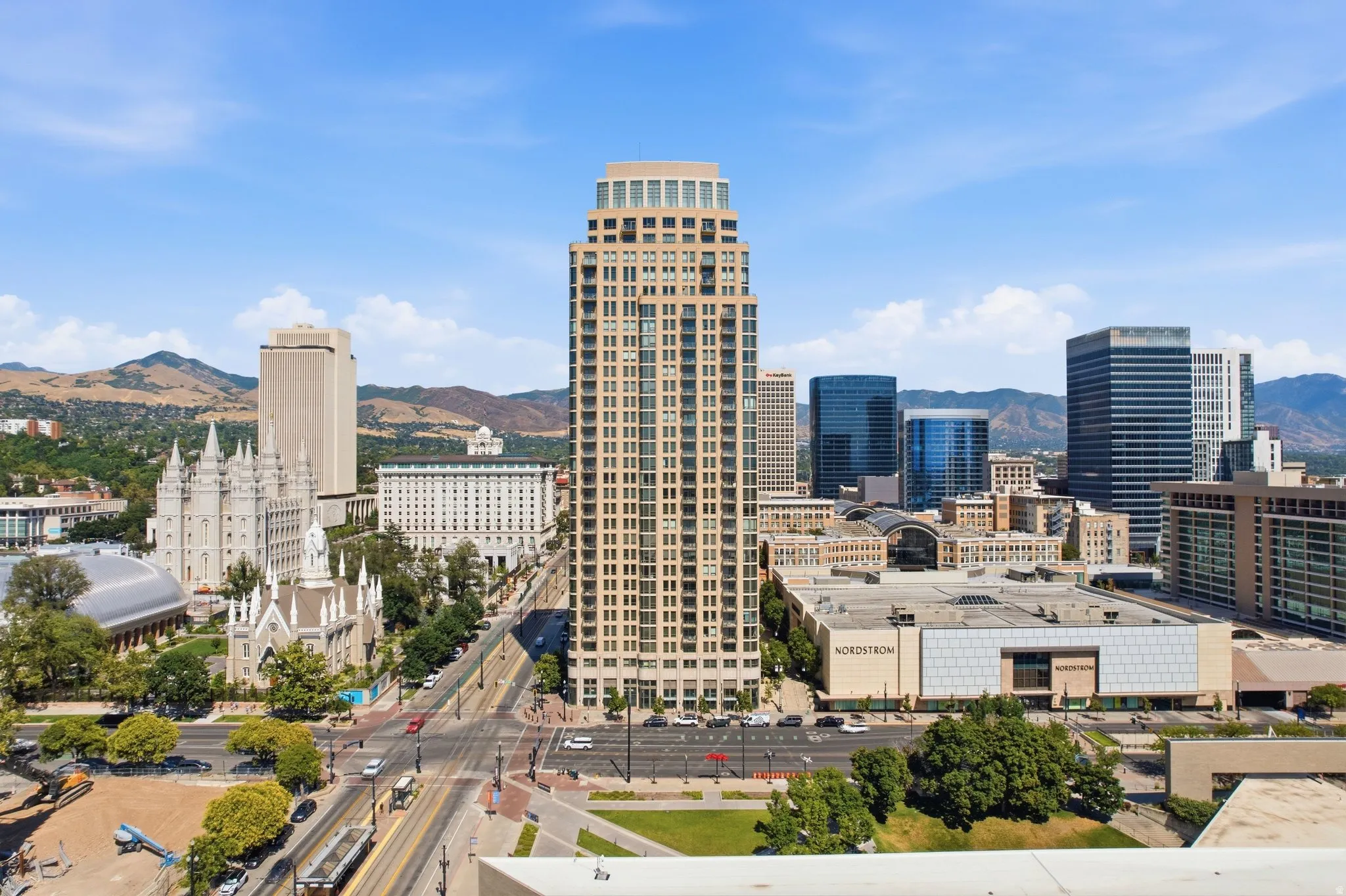 Expansive cityscape featuring a prominent high-rise building with numerous windows, surrounded by additional commercial and architectural structures