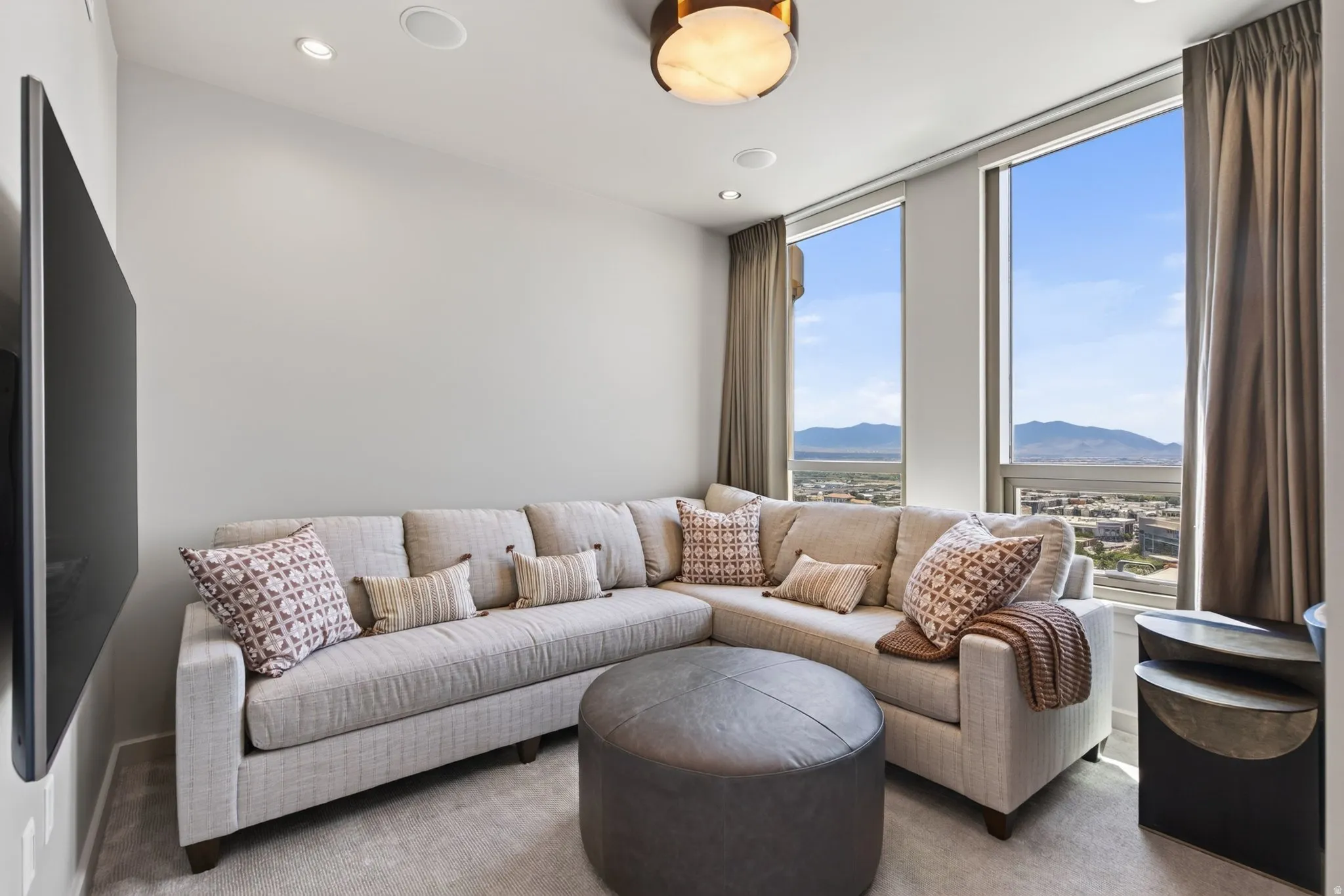 Living area featuring expansive windows with mountain and city scenery