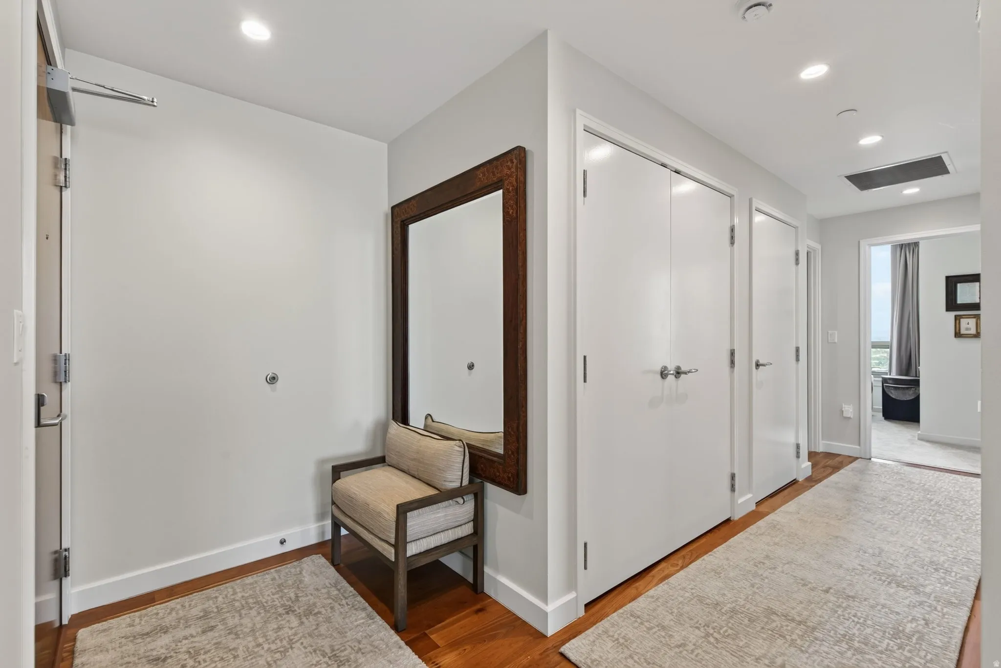 Entry foyer featuring wood-finish flooring, recessed lighting, and multiple white panel doors