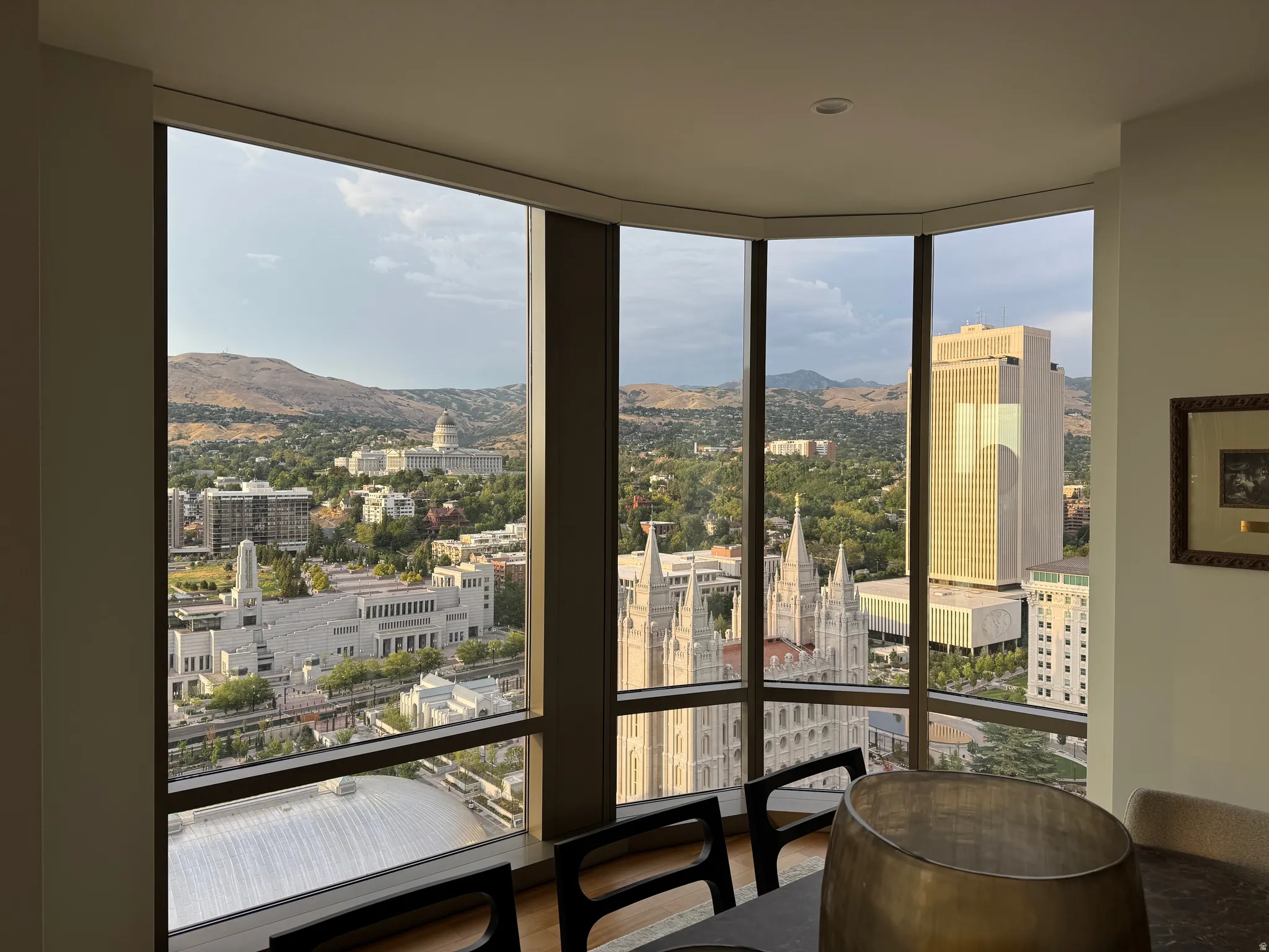 Expansive corner windows showcasing city and mountain landscapes