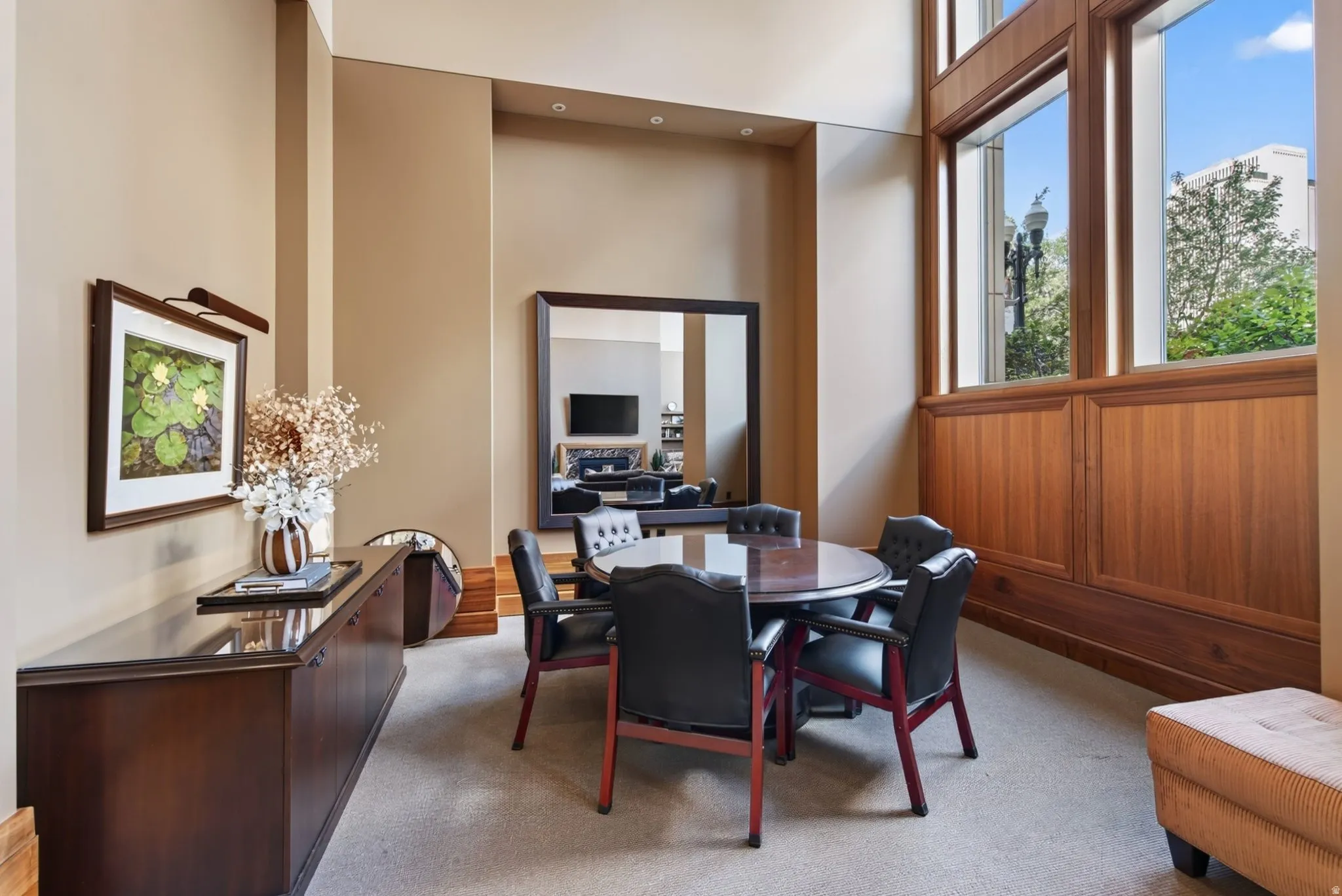 Double-height space featuring extensive wood-paneled walls and large windows