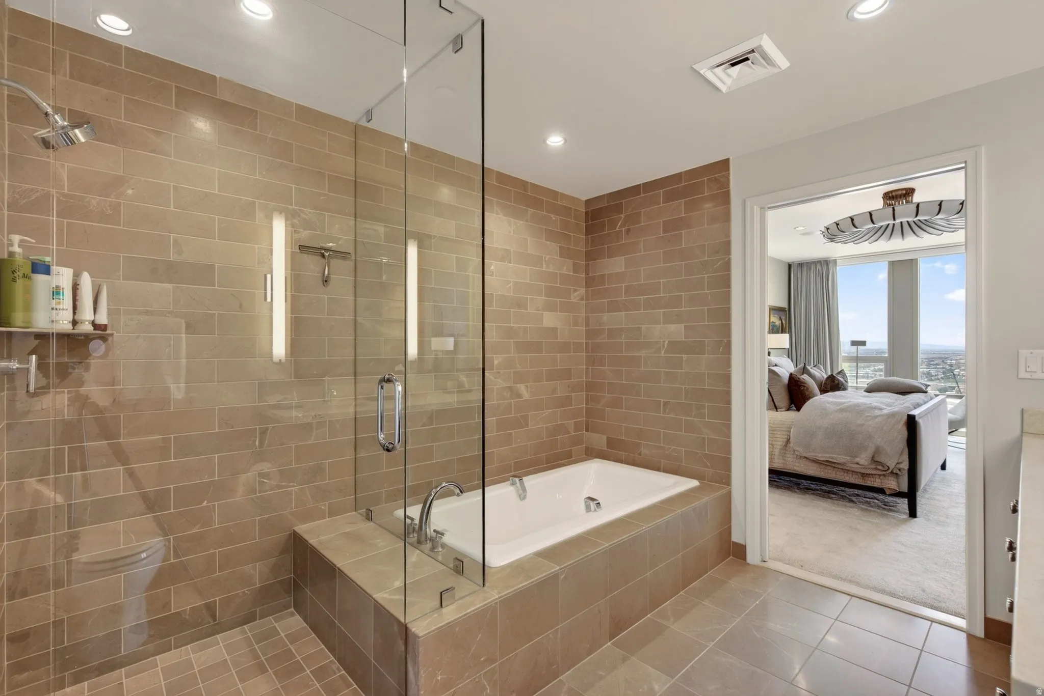 Walk-in shower featuring glass enclosure, subway tile surround, recessed lighting, and a built-in soaking tub
